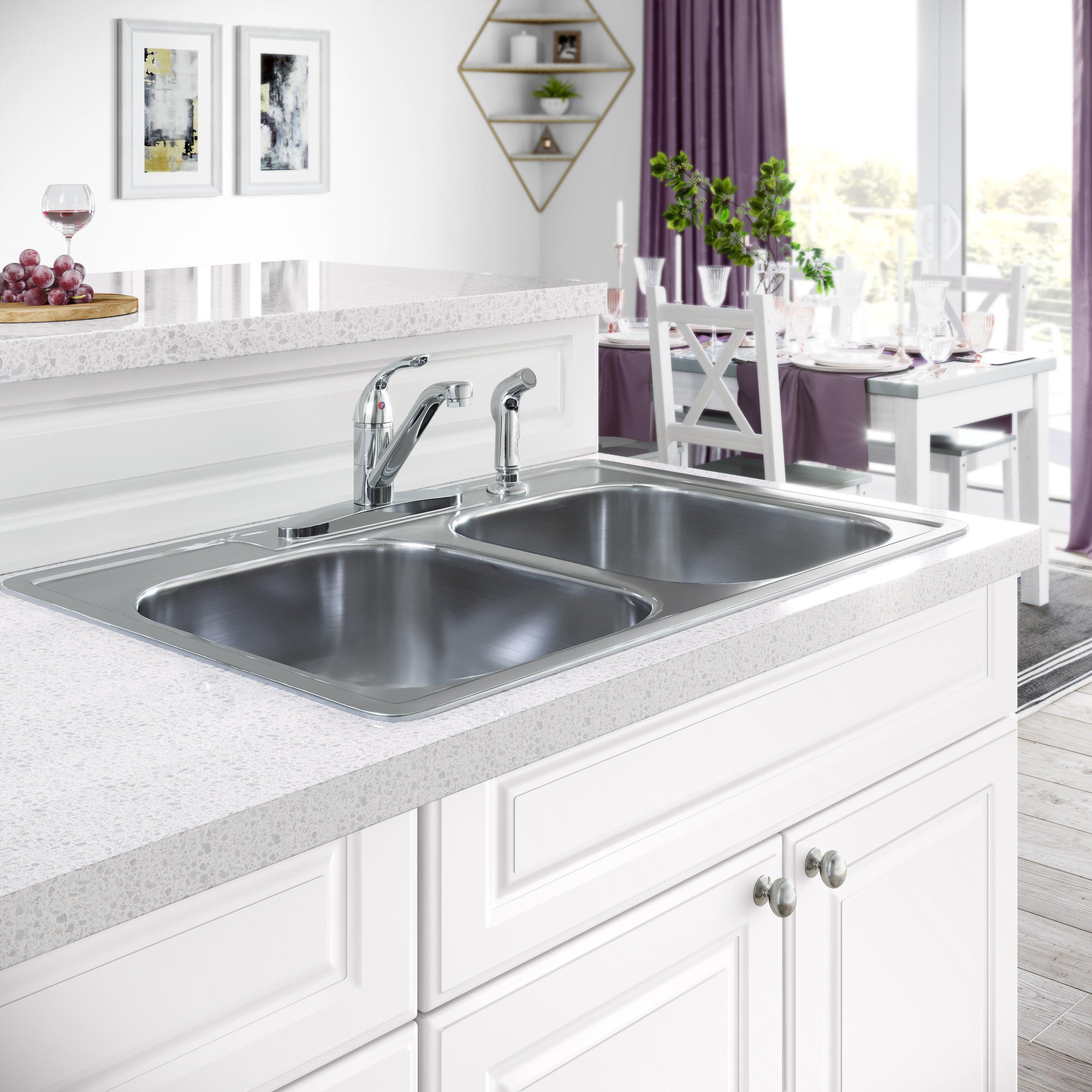 A white kitchen with a sliver sink and faucet